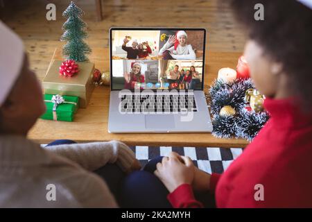 Ein afroamerikanisches Paar, das ein weihnachtsvideo mit verschiedenen Leuten führt Stockfoto
