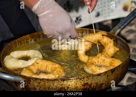 Nahaufnahme eines Arbeiters, der Donuts kocht Stockfoto