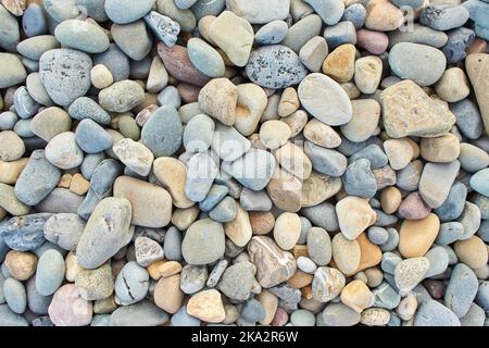 Steinhintergrund - Kieselsteine Textur. Kopfsteinpflaster. Detailansicht von Mustern aus Strandsteinen und Kieselsteinen. Stockfoto