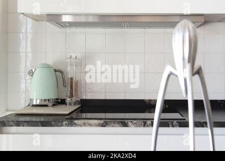 Designer-Entsafter und kleine Geräte auf der Arbeitsplatte aus schwarzem Marmor Stockfoto