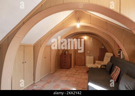 Seltsames Zimmer in einem Dachboden mit halbrunden Bögen mit Holz bedeckt Stockfoto
