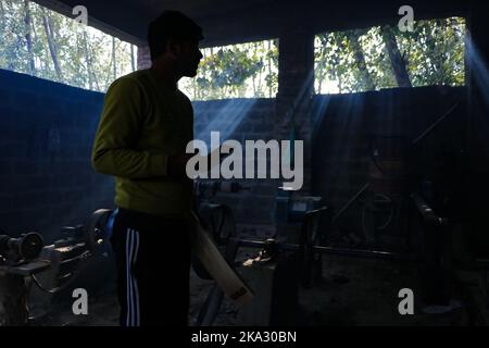 31. Oktober 2022, Bijhbehara, Jammu und Kaschmir, Indien: Ein Arbeiter steht in der Nähe einer Maschine, während er in einer Fabrik in Sangam einen Cricket-Schläger macht. Kashmiri Weide hat einen bedeutenden Ausflug in die internationale Cricket gemacht, vor kurzem wurde von einigen Spielern bei der Weltmeisterschaft T20 und der Legends Cricket League verwendet. (Bild: © Adil Abbas/ZUMA Press Wire) Stockfoto