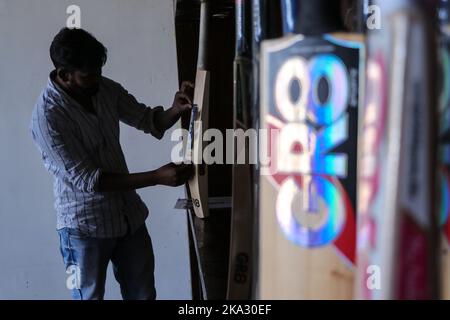 31. Oktober 2022, Bijhbehara, Jammu und Kashmir, Indien: Ein Arbeiter fügt in einer Fabrik in Sangam Brandsticker zu Cricket-Fledermäusen hinzu. Kashmiri Weide hat einen bedeutenden Ausflug in die internationale Cricket gemacht, vor kurzem wurde von einigen Spielern bei der Weltmeisterschaft T20 und der Legends Cricket League verwendet. (Bild: © Adil Abbas/ZUMA Press Wire) Stockfoto