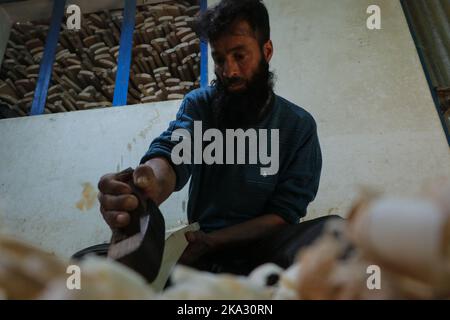 31. Oktober 2022, Bijhbehara, Jammu und Kashmir, Indien: Ein Arbeiter formt eine Weide mit einem Holzbearbeitungswerkzeug, um Cricket-Schläger in einer Fabrik in Sangam herzustellen. Kashmiri Weide hat einen bedeutenden Ausflug in die internationale Cricket gemacht, vor kurzem wurde von einigen Spielern bei der Weltmeisterschaft T20 und der Legends Cricket League verwendet. (Bild: © Adil Abbas/ZUMA Press Wire) Stockfoto