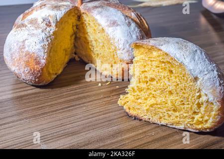 Kürbisbrot in Form eines Kürbisses auf einem Holztisch. Stockfoto