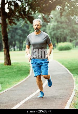 Senior Fitness Mann aktiv Sport Übung Laufen Joggen gesund Läufer fit Jogger Workout Sportler Training Marathon Geschwindigkeit Ältere gary Haare Stockfoto