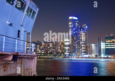 Eine Nachtaufnahme von Gebäuden in Canary Wharf spiegelte sich im Wasser, London Stockfoto