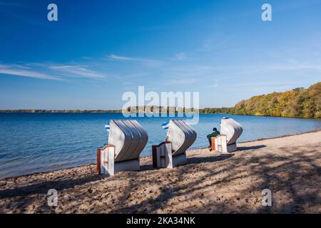 Herbstliche Stimmung, an der Badestelle auf der Prinzeninsel im Großen Plöner See. Strandkörbe beladen ein zum Verweihen Stockfoto