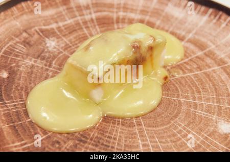 Typisches Essen des Baskenlandes Cod al pil pil serviert auf einem imitierten Holzteller Stockfoto