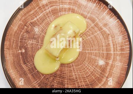 Typisches Essen des Baskenlandes Cod al pil pil serviert auf einem imitierten Holzteller Stockfoto