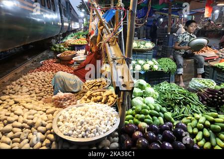 Dhaka, Dhaka, Bangladesch. 31. Oktober 2022. Ein Pendlerzug fährt durch den Jurain Railgate Markt in Dhaka. Verkäufer verkaufen Obst und Gemüse nur wenige Zentimeter von der Bahnlinie entfernt. Zwei Züge fahren pro Stunde mit einer Geschwindigkeit von etwa 30 Kilometern durch diesen Markt. (Bild: © Syed Mahabubul Kader/ZUMA Press Wire) Stockfoto