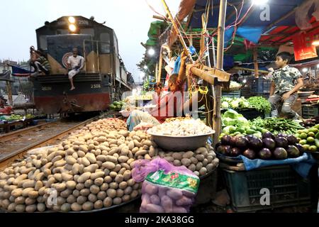 Dhaka, Dhaka, Bangladesch. 31. Oktober 2022. Ein Pendlerzug fährt durch den Jurain Railgate Markt in Dhaka. Verkäufer verkaufen Obst und Gemüse nur wenige Zentimeter von der Bahnlinie entfernt. Zwei Züge fahren pro Stunde mit einer Geschwindigkeit von etwa 30 Kilometern durch diesen Markt. (Bild: © Syed Mahabubul Kader/ZUMA Press Wire) Stockfoto