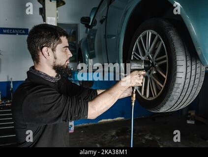 Mechaniker mit Schraubendreher Reparatur Autorad in der Werkstatt Stockfoto