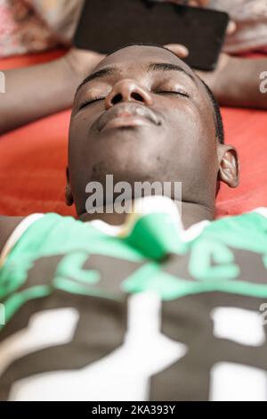 Afroamerikanischer Mann schläft auf dem Bett Stockfoto