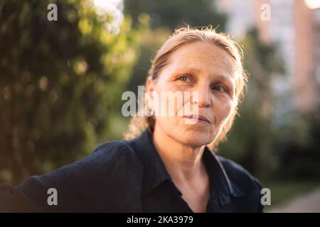 Porträt einer durchdachten, reifen Geschäftsfrau, die im Park wegschaut Stockfoto