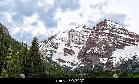 Maroon Bells Lake in Aspen, Colorado während der blauen Stunde wolkige Morgendämmerung vor Sonnenaufgang mit felsigen Berggipfeln im Frühsommer-Panorama und niemand Stockfoto