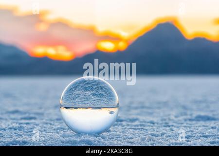 Kristallkugel Makro Nahaufnahme Bodenansicht des runden Glasglobus mit Spiegelung der Bonneville Salzebenen und Berge bei farbenfrohem Sonnenuntergang mit Orang Stockfoto