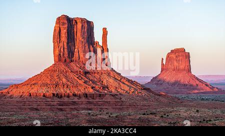 Zwei Fäustlinge butte mesa Nahaufnahme mit farbenfroher dunkelroter oranger Felsfarbe am Horizont in den Monument Valley Canyons während des Sonnenuntergangs in Arizona Stockfoto