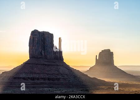 Nahaufnahme von Ost- und Westkampen und Horizont im Monument Valley bei Sonnenaufgang buntes Licht und Sonnenstrahlen hinter Felsformationen in Arizona Stockfoto