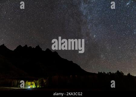 Kastanienbraune Glocken Seengebiet mit Sternen in milchiger und dunkler Nacht Sternenhimmel in Aspen, Colorado mit Silhouette von felsigen Berggipfeln und herbstlichen Herbstbäumen Stockfoto