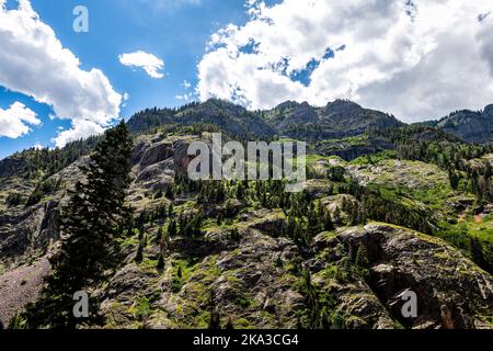 Blick auf die Felswand der Felsschlucht in der Nähe des Ouray Colorado Million Dollar Highway mit felsigen Bergen von San Juan im Sommer, blauer Himmel Wolke Stockfoto