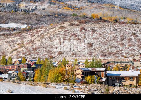 Aspen, Colorado felsige Berge mit Ranch Farm Weide bedeckt mit Schnee nach dem Winter mit gelben Herbstbäumen, Häuser von Berg Stadtbild Stockfoto