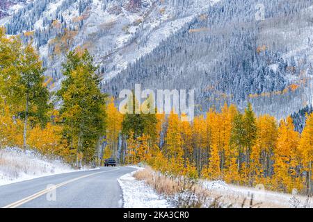 Wald gelb grünen Bäumen mit Schnee bedeckt in Aspen, Colorado von Maroon Glocken Berge durch lebendige Laub Herbst entlang der Straße mit Auto fahren Stockfoto