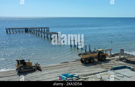 Fort Myers Beach, Usa. 30. Oktober 2022. In dieser Luftaufnahme reparieren Lastwagen den Strand in der Nähe der Überreste des stark beschädigten Pier in Fort Myers Beach, Florida, einen Monat nachdem Hurrikan Ian am 28. September als Hurrikan der Kategorie 4 landeten, Verursacht geschätzte $67 Milliarden an versicherten Schäden und mindestens 127 stürmbedingte Todesfälle in Florida. Kredit: SOPA Images Limited/Alamy Live Nachrichten Stockfoto