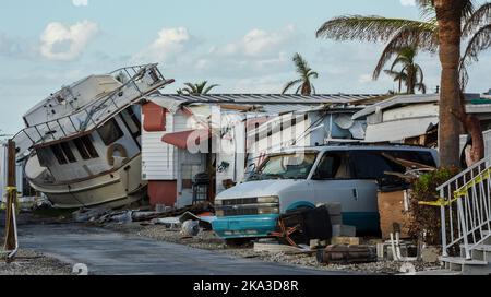 Fort Myers Beach, Usa. 30. Oktober 2022. Ein Boot und ein beschädigtes Fahrzeug werden unter Anhängern in einem Mobilhome-Park in Fort Myers Beach, Florida, einen Monat nach Hurrikan Ian, der am 28. September als Hurrikan der Kategorie 4 landet, gesehen. Verursacht geschätzte $67 Milliarden an versicherten Schäden und mindestens 127 stürmbedingte Todesfälle in Florida. Kredit: SOPA Images Limited/Alamy Live Nachrichten Stockfoto