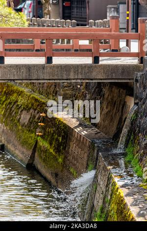 Kleine rote Zinnoberbrücke über den Fluss Enako in Takayama, Japan der Präfektur Gifu, wo im Frühjahr im traditionellen Dorf Wasser fließt Stockfoto