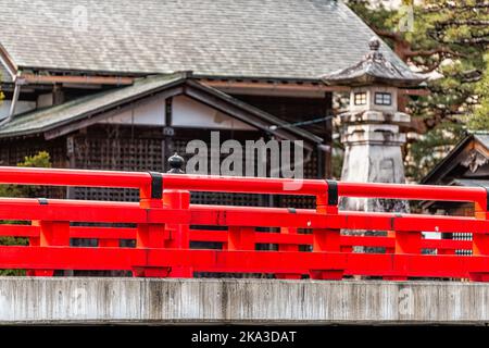 Rote Zinnoberfarbenbrücke über den Enako-Fluss Steinpfad in Takayama, Japan, auf dem Higashiyama Walking Course in der historischen Stadt GIF Stockfoto