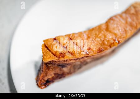 Makro Nahaufnahme von frischem Grill gekocht gebackenen Schweinefleisch Bauch Fett Speck Fleisch, nahrhafte Lebensmittel vor weißem Teller Hintergrund isoliert Stockfoto