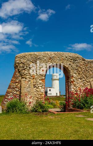 Die Ruinen der St. Edmund's Chapel, erbaut 1272, mit dem ehemaligen Leuchtturm im Hintergrund in Old Hunstanton, einem Badeort in Norfolk England. Stockfoto