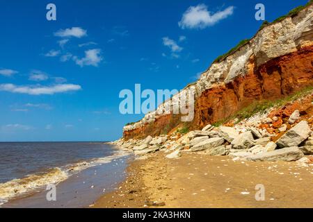 Blick auf die geschichteten Kreidefelsen mit rotem Kalkstein und weißen Kalkfelsen am Strand von Old Hunstanton im Westen Norfolk England. Stockfoto