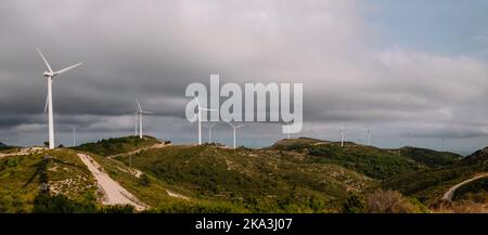 Panoramablick Auf Die Windmühlen In Den Bergen Gegen Den Wolkigen Himmel Stockfoto