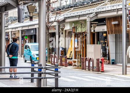 Takayama, Japan - 6. April 2019: Stadt der Präfektur Gifu mit Einkaufspassage auf einer überdachten Straße, die im Frühjahr farbenfrohe Schilder mit Menschen aufgehängt hat Stockfoto