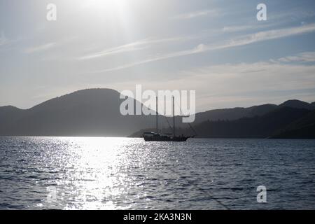 Schöne Bucht mit Segelboot, Yacht im türkisfarbenen Meer, Luxusurlaub oder Segelregata Sport. Stockfoto