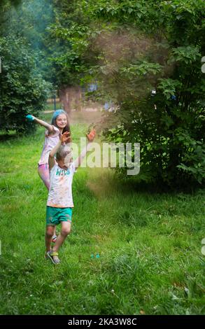 Lviv, Ukraine - 18. Juli 2021: Color Holi Festival, Junge und Mädchen werfen farbige Farbe. Der Urlaub kommt aus Indien Stockfoto