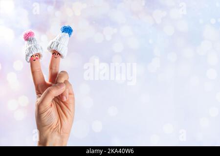 Lustige Cartoon Finger Figuren in Hüten. Finger mit fröhlichen Gesichtern in Wintermützen auf schneebedeckten festlichen Lichtern im Hintergrund kopieren Raum. Weihnachtsurlaub, f Stockfoto