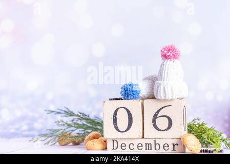 Sinterklaas, St. Nikolaus Tag Hintergrund. Kinder Wintermützen, Block Kalender mit Dezember 6 Datum, pepernoten, Süßigkeiten. Niederländische Weihnachtsfeiertage Gruß Stockfoto