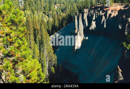 Die Pinnacles, vulkanische Schlote am Rand des Krater-Sees im Oregon Park. Mit einem Kiefernwald, der um die spitzen Türme wächst. Stockfoto