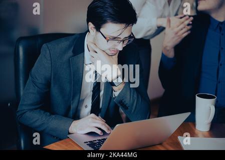 Junger seriöser professioneller Geschäftsmann, fokussierter Student, der eine Brille am Laptop trägt Stockfoto