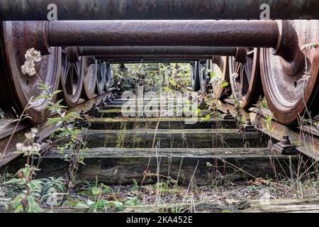 Eine Nahaufnahme der alten rostigen Zugräder auf Schienen Stockfoto