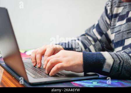 Eine Person aus nächster Nähe, die auf einer Laptop-Tastatur tippt Stockfoto