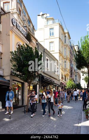 Blick auf die Menschen, die auf einer der touristischen Einkaufsstraßen namens Galip Dede Caddesi im historischen Galata-Viertel von Istanbul spazieren gehen. Es ist ein sonniger Sommer Stockfoto