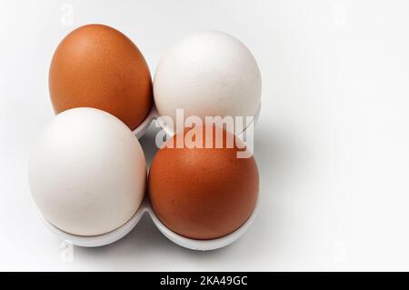 Zwei weiße und zwei braune Bio-Eier von Freilandhühnern. Stockfoto