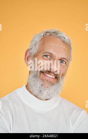 Glücklicher alter älterer Mann, isoliert auf gelbem, vertikalem Kopfbild-Porträt. Stockfoto