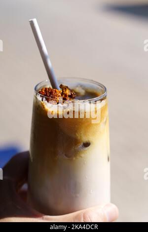 Dalgona Kaffee. Eiskaffeegetränk mit Zucker und Milch auf einer Glastasse auf einem Tisch in einem Café. Trendige kalte Getränke, koreanisches Speisekonzept. Hochwertige Fotos Stockfoto