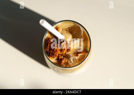 Dalgona Kaffee. Eiskaffeegetränk mit Zucker und Milch auf einer Glastasse auf einem Tisch in einem Café. Trendige kalte Getränke, koreanisches Speisekonzept. Hochwertige Fotos Stockfoto