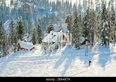 Winterlandschaft mit verschneiten Bergen und schönen Holzchalets Stockfoto